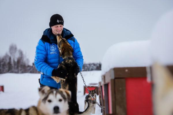 a dog lunges onto a person in a blue jacket